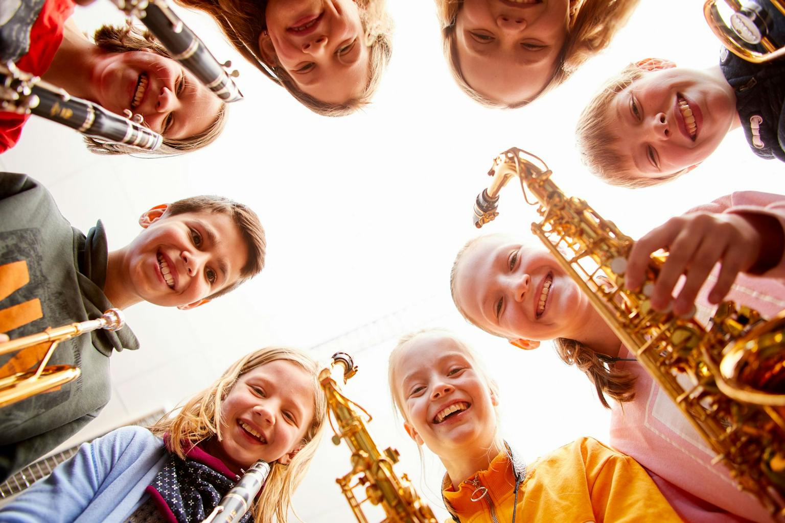 Niños en círculo con instrumentos de viento