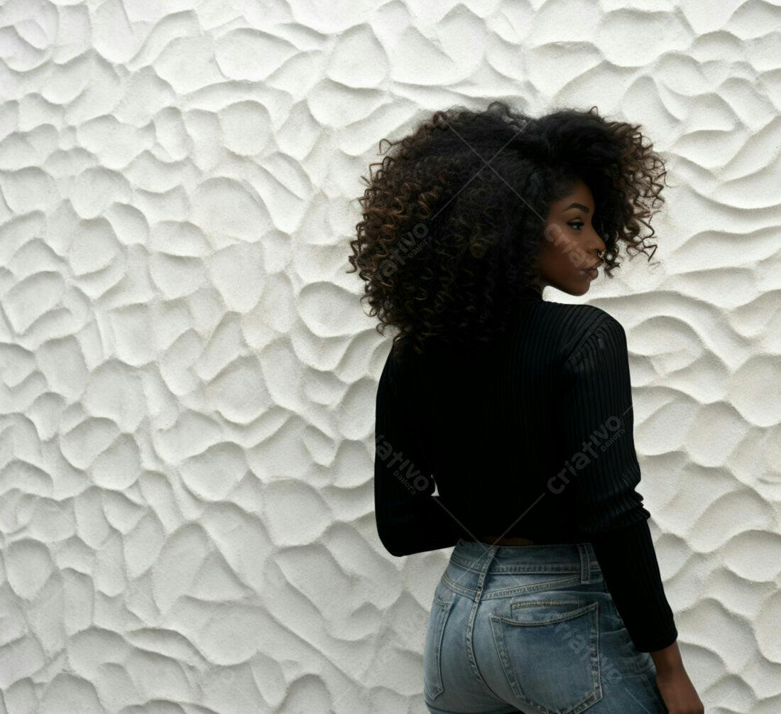 Mulher negra com cabelo afro usando blusa preta e jeans