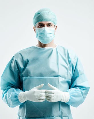 Médico em traje cirúrgico completo, com máscara e luvas, postura confiante, fundo branco 21
