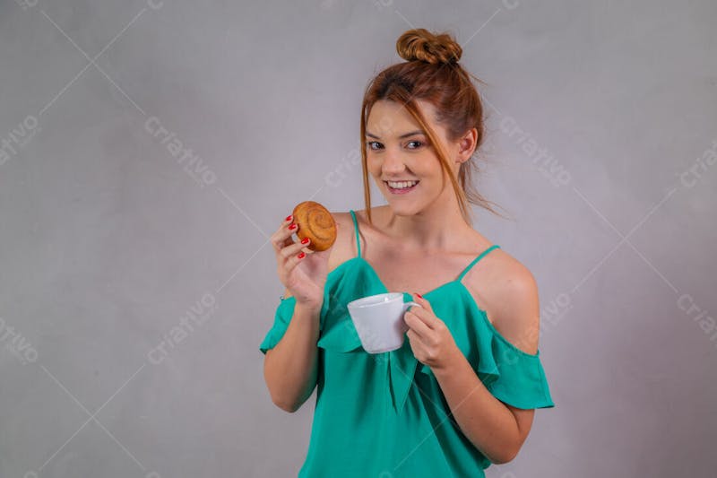 Jovem bonita comendo donuts chocolate tomando café camiseta verde