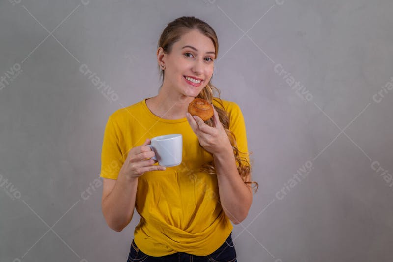 Jovem bonita loira comendo donuts chocolate tomando café camiseta amarela 3