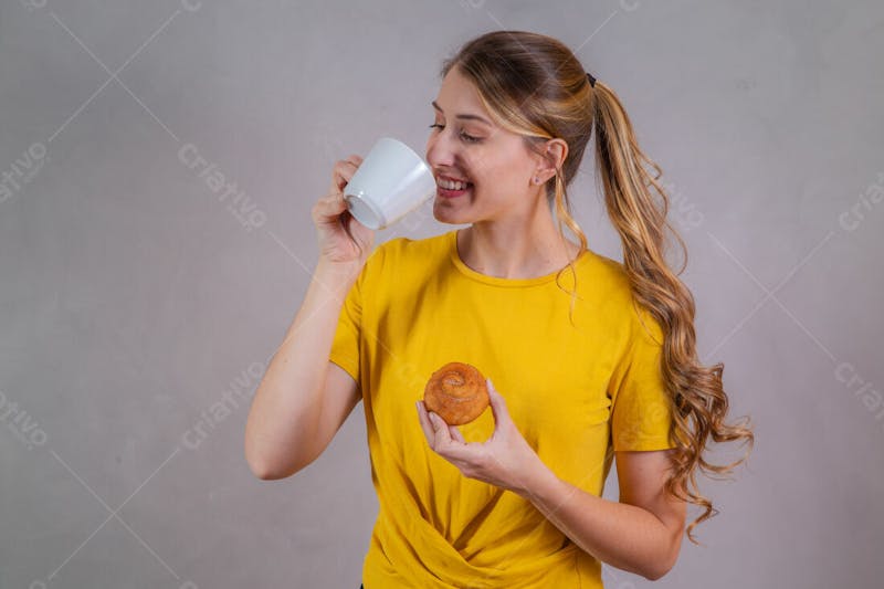Jovem bonita loira comendo donuts chocolate tomando café camiseta amarela