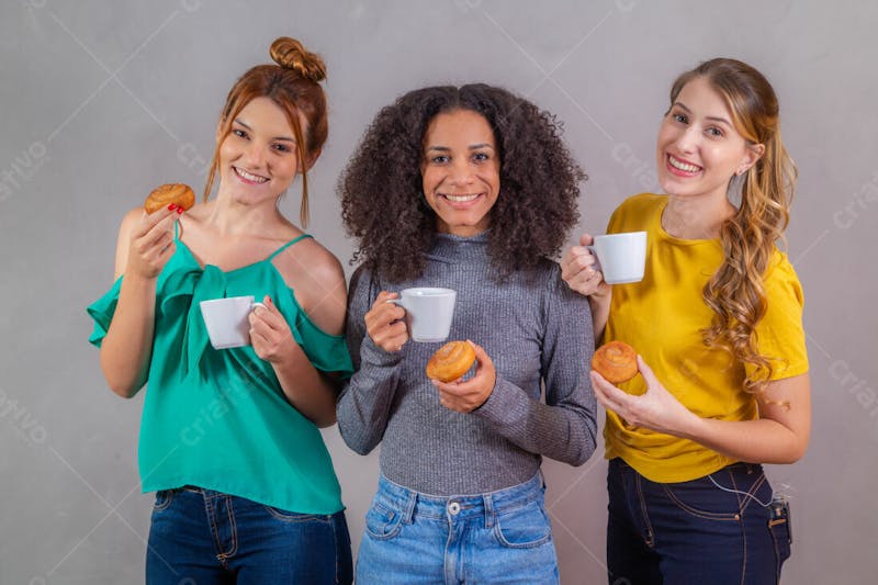Mulheres jovens bonitas amigas comendo donutes e tomando café 1