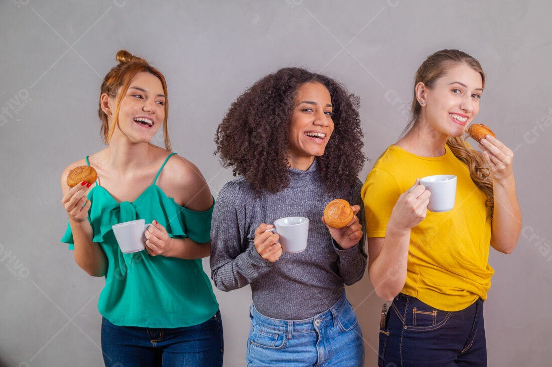Amigas tomando café e comendo doces sorrindo