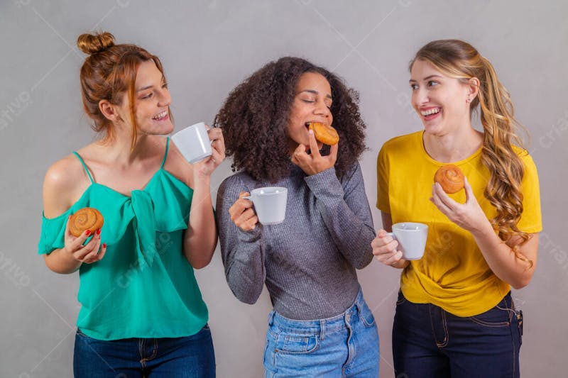 Mulheres jovens bonitas amigas comendo donutes e tomando café 6
