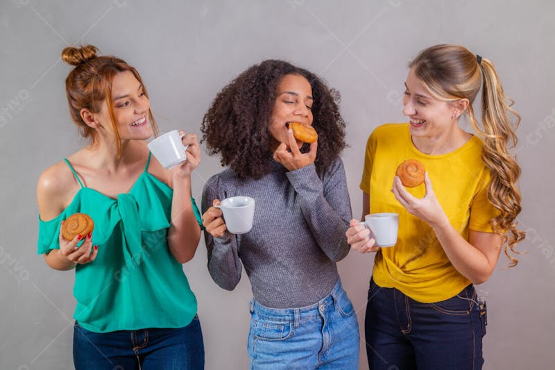 Mulheres jovens bonitas amigas comendo donutes e tomando café 7