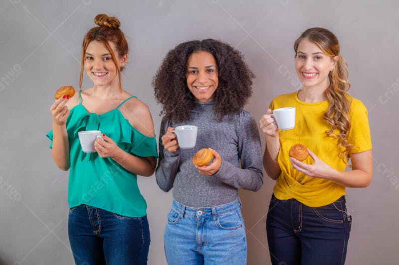 Mulheres jovens bonitas amigas comendo donutes e tomando café