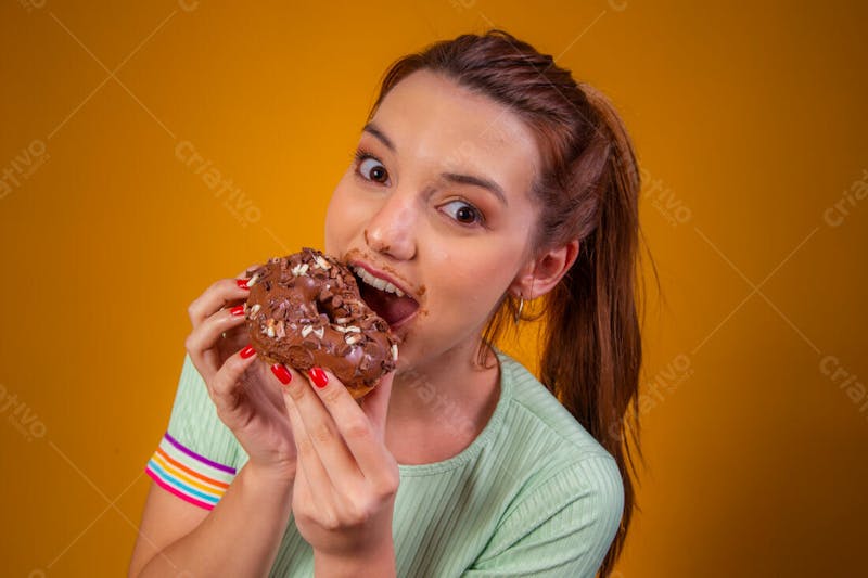 Jovem bonita comendo donuts chocolate camiseta verda 6