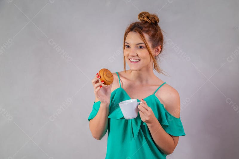 Jovem bonita comendo donuts chocolate tomando café camiseta verde 1