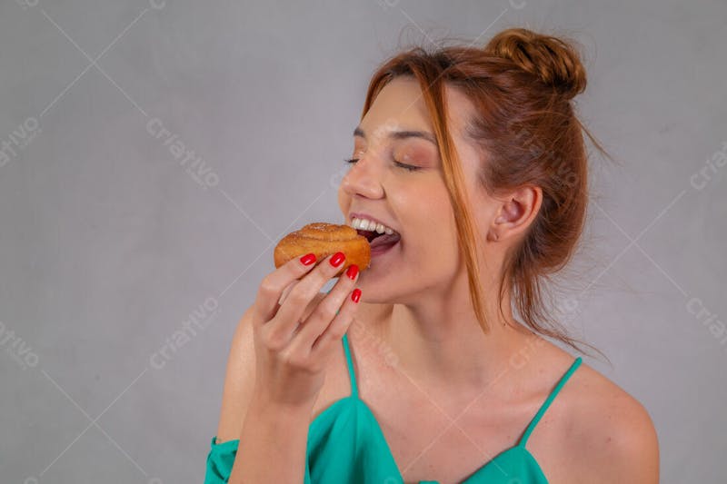 Jovem bonita comendo donuts chocolate tomando café camiseta verde 7