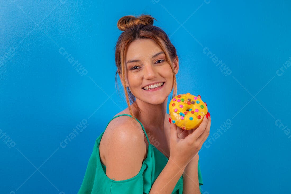 Mulher jovem segurando donut amarelo