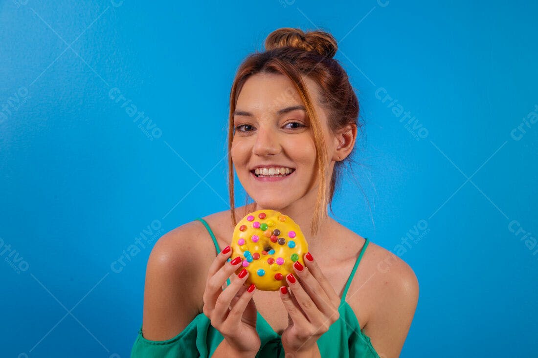 Mulher sorrindo com donut amarelo