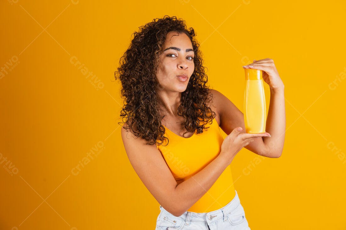 Mulher com cabelo cacheado mostrando shampoo amarelo