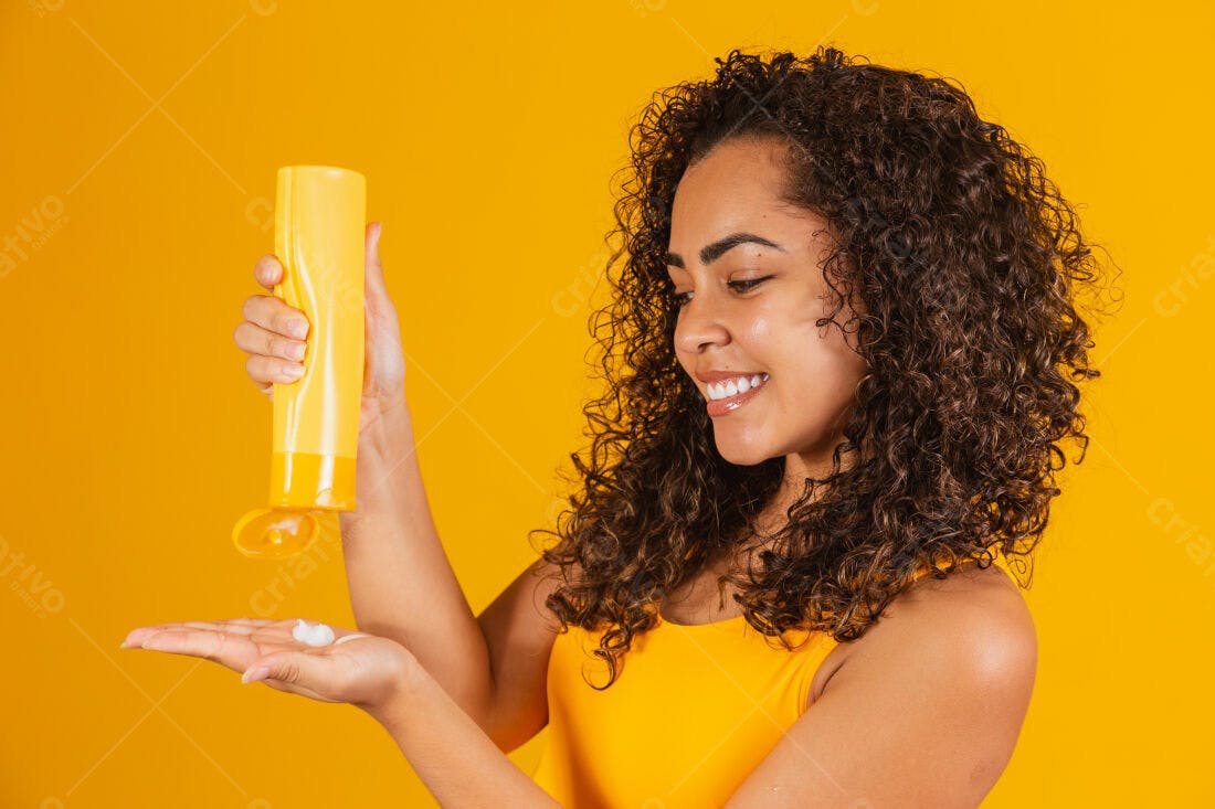 Mulher aplica creme em fundo amarelo