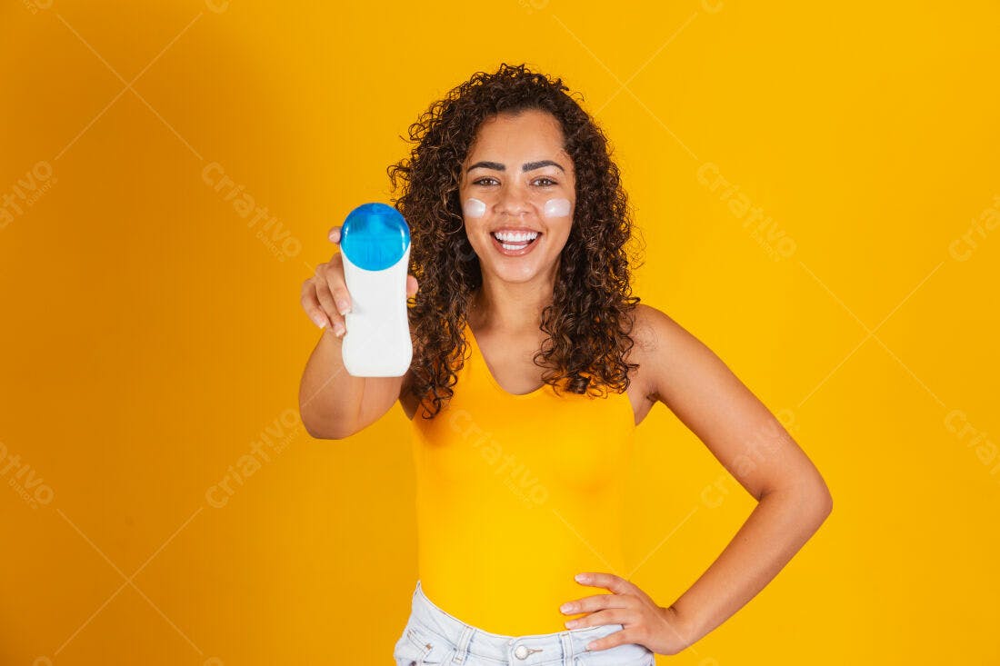 Mulher negra mostrando protetor solar fundo amarelo