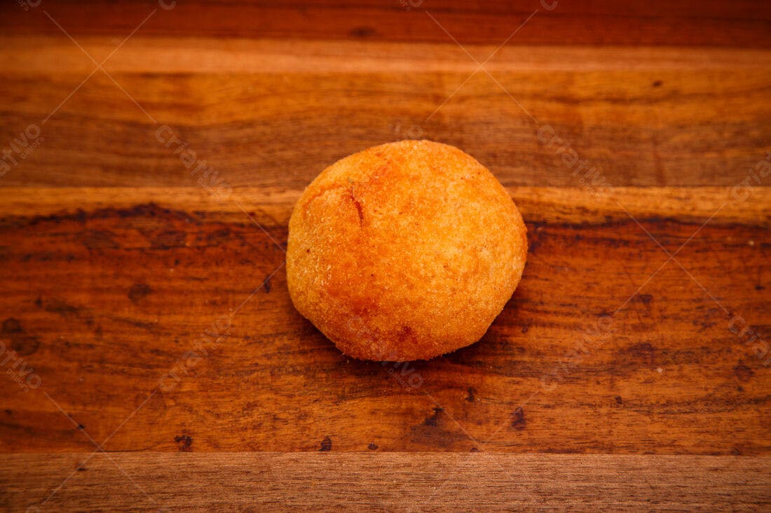Bolinha de queijo frita sobre madeira