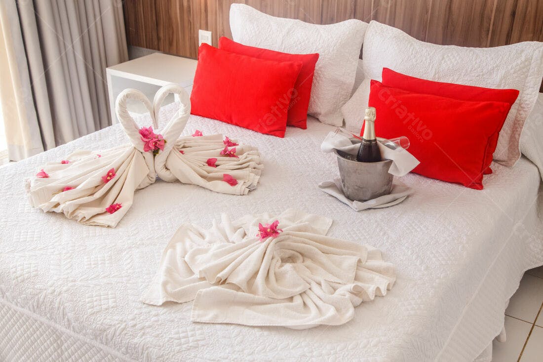 Cama de hotel decorada para casal com toalhas em formato de cisnes