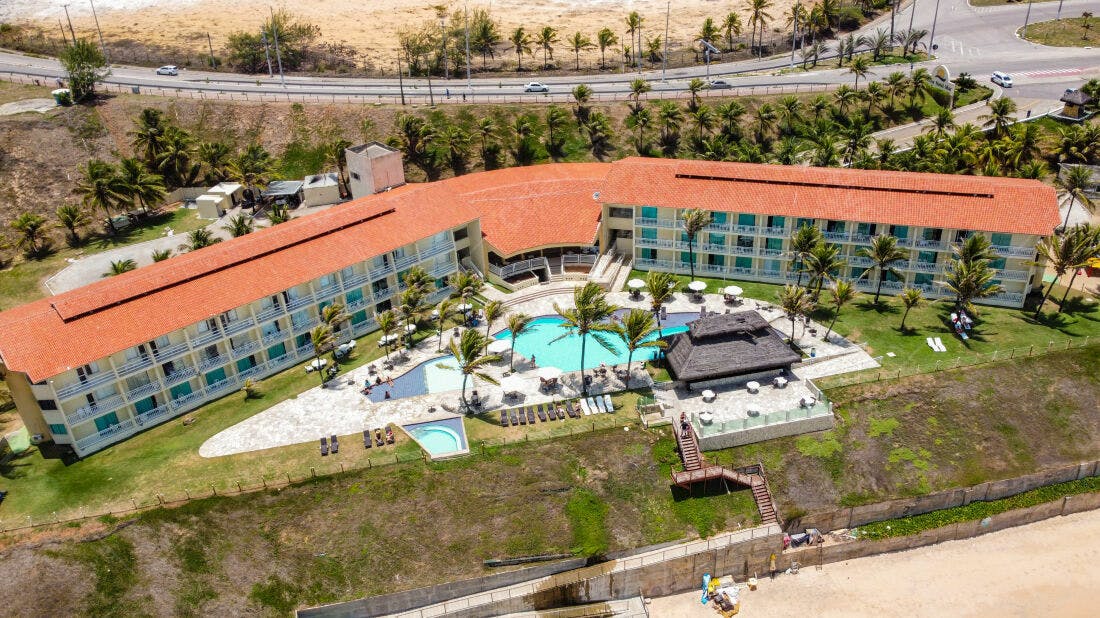 Hotel beira-mar com piscina e palmeiras