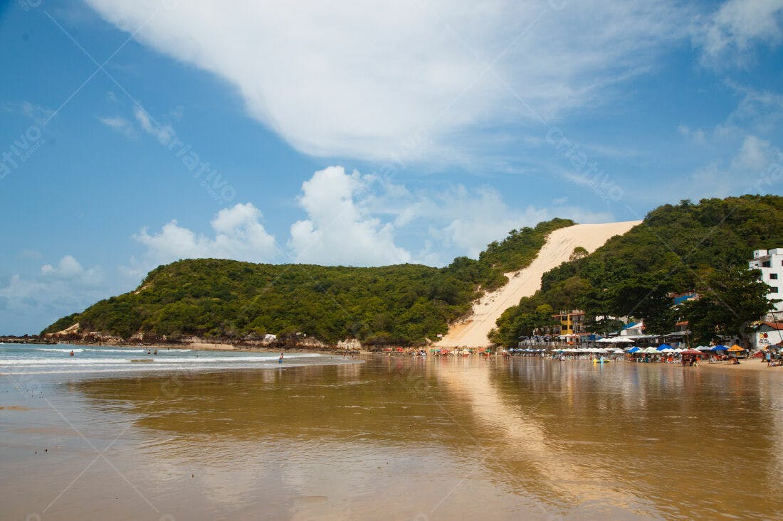 Praia com duna de areia e mar calmo
