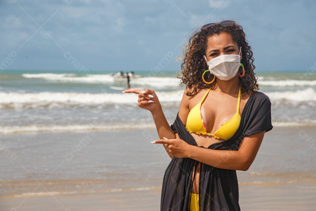 Mulher na praia usando máscara amarela