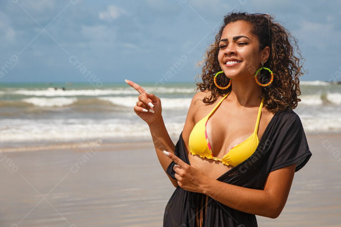 Mulher na praia apontando para o mar