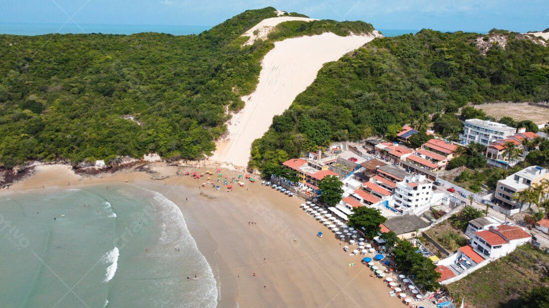 Praia tropical com dunas e casas