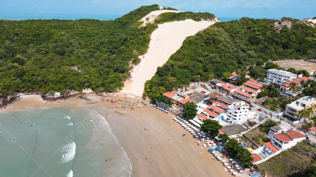 Praia tropical com dunas e casas coloridas