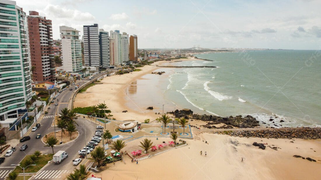 Praia urbana com prédios e mar azul