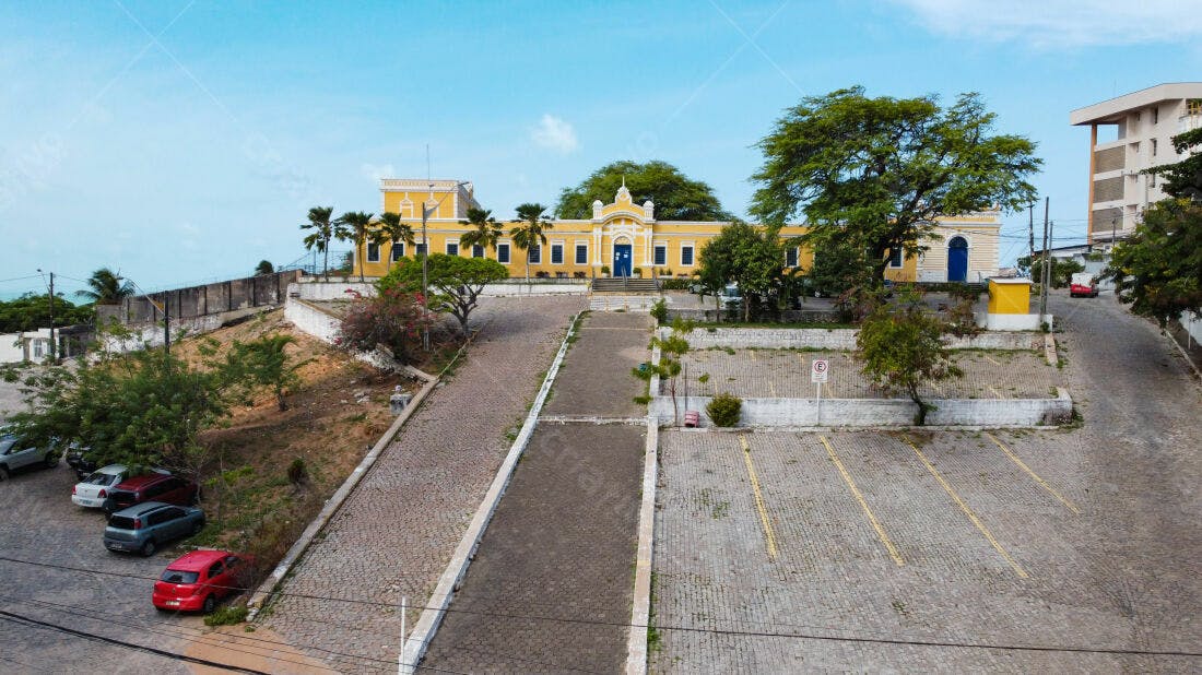 Edifício colonial amarelo em praça pavimentada