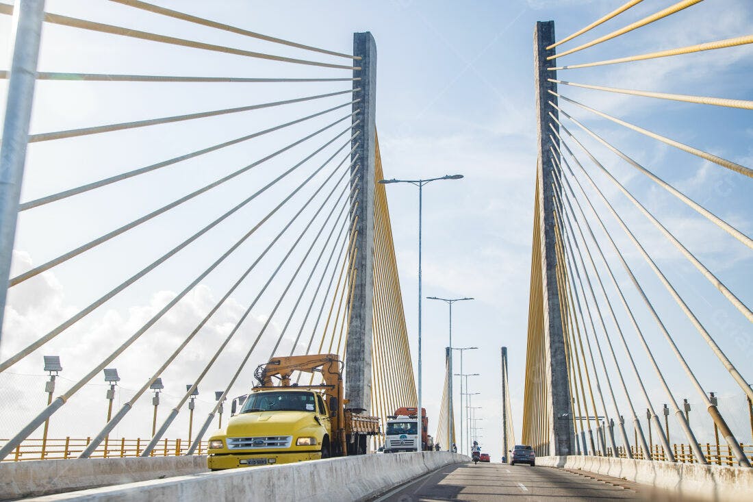 Caminhão amarelo em ponte estaiada moderna