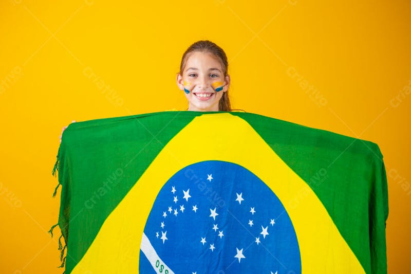 Criança segurando a bandeira do brasil torcedora