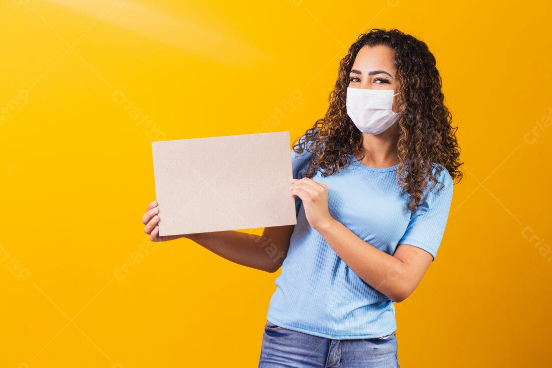 Mulher com máscara segurando cartaz amarelo