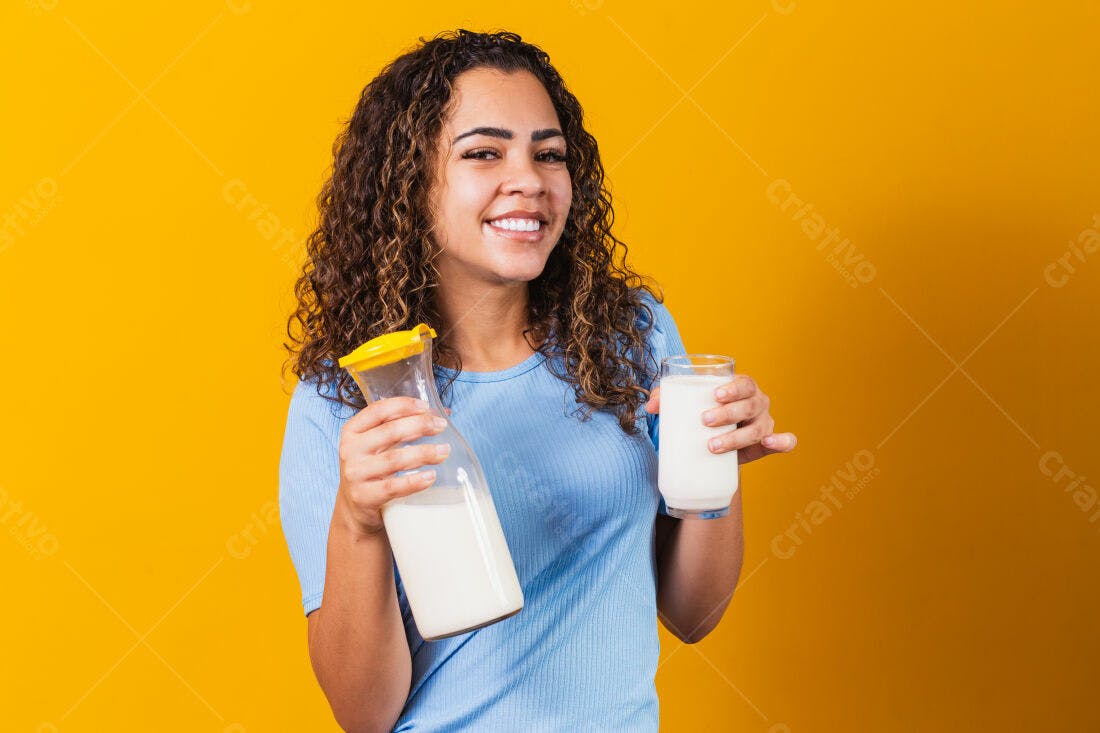 Mulher sorridente segurando leite fundo amarelo