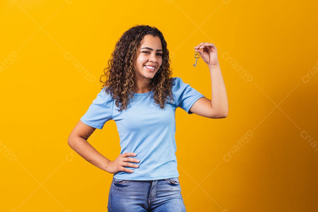Mulher sorridente segurando chave fundo amarelo