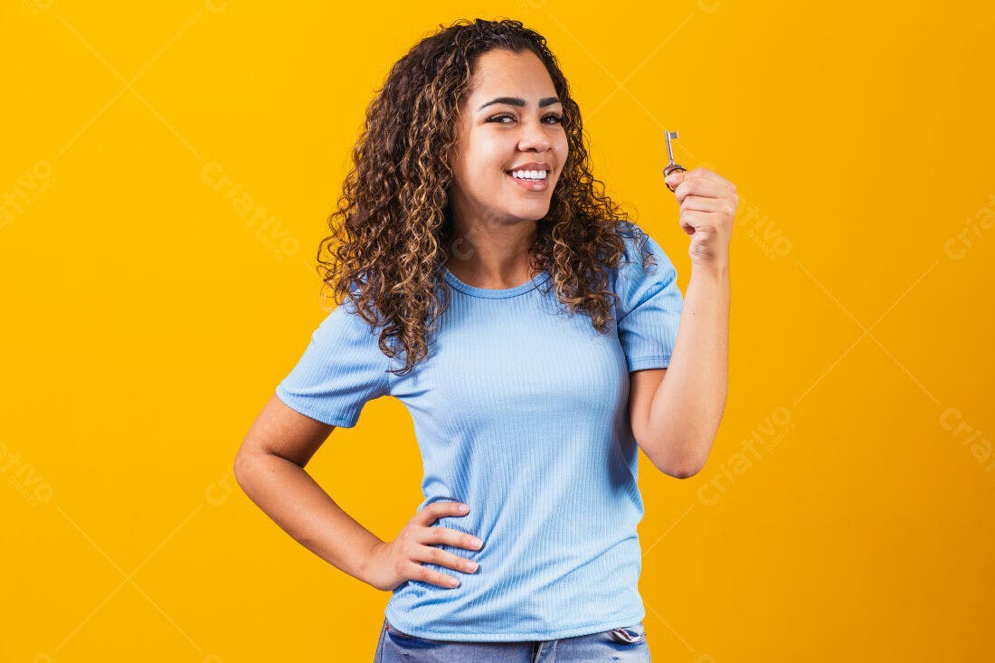 Mulher feliz segurando chave fundo amarelo
