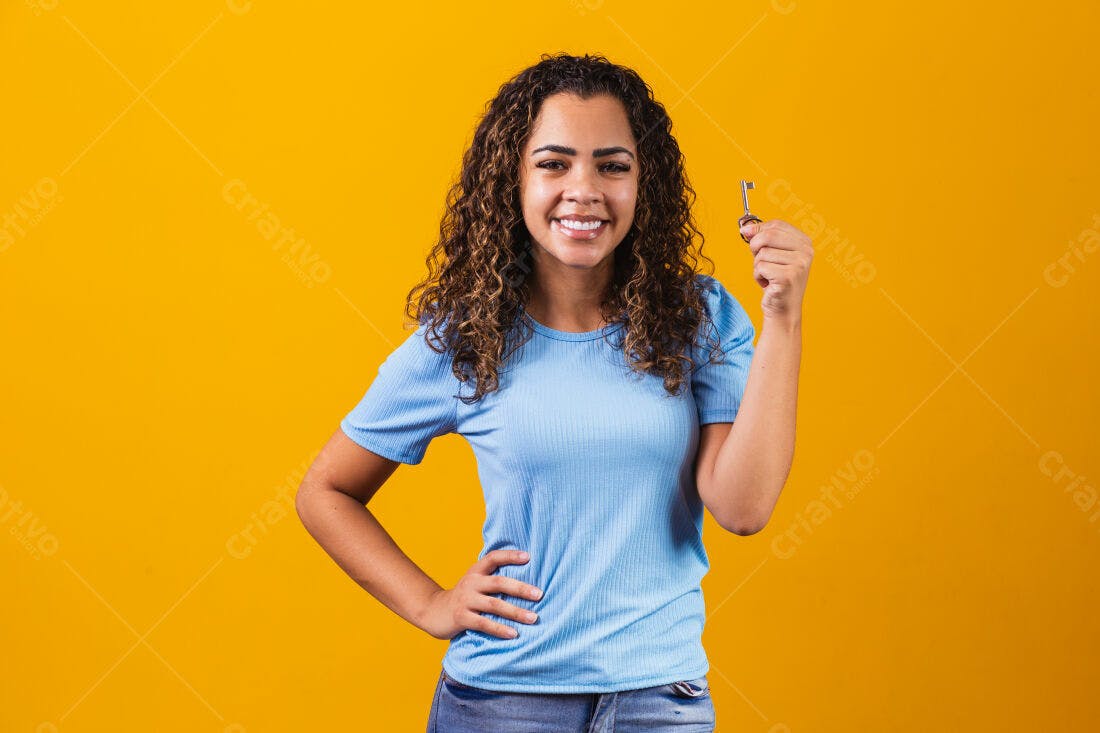 Mulher feliz mostrando chave fundo amarelo