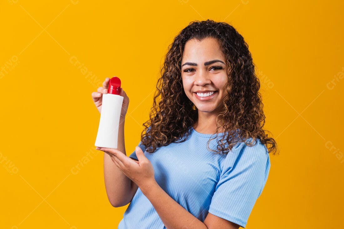 Mulher sorridente mostrando frasco de produto cabelo