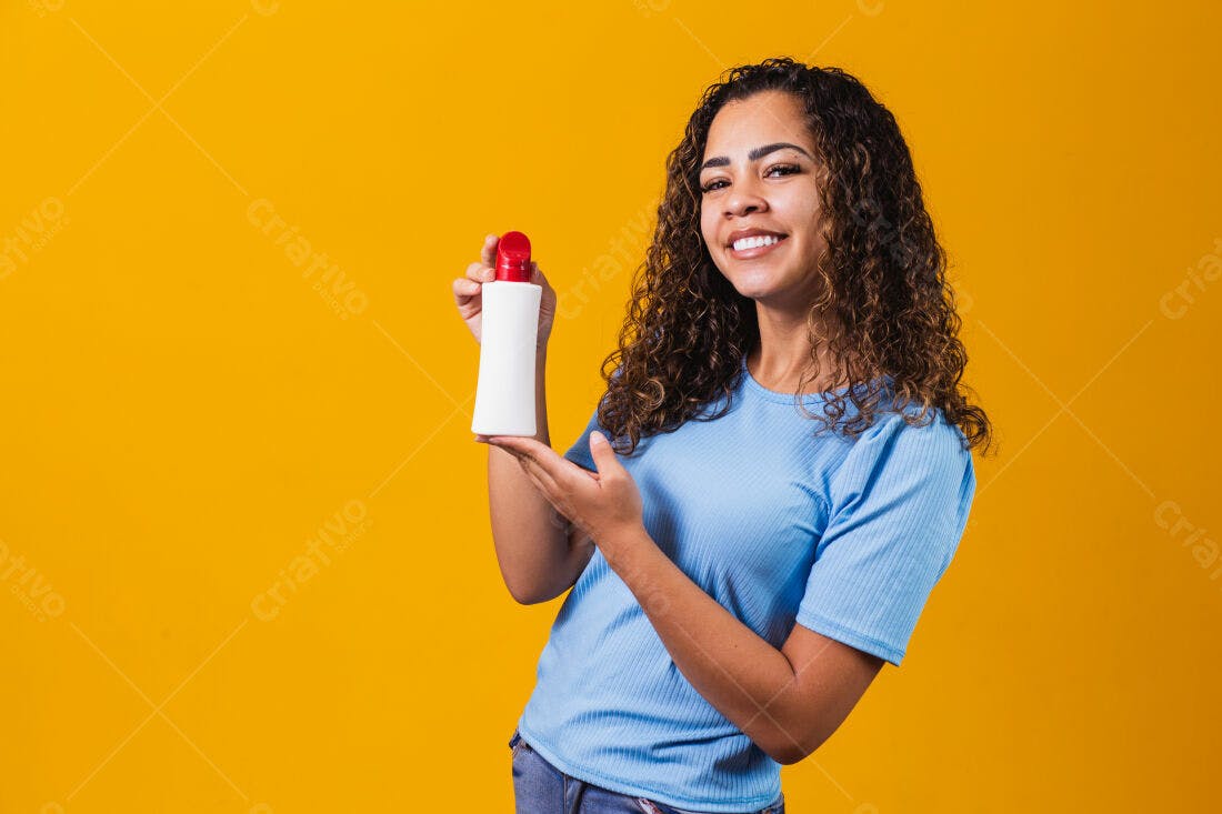 Mulher mostrando produto de beleza fundo amarelo