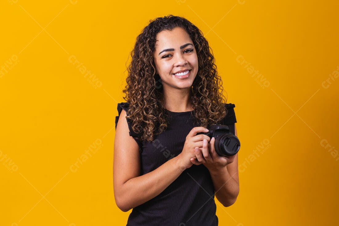 Fotógrafa sorridente com câmera fundo amarelo