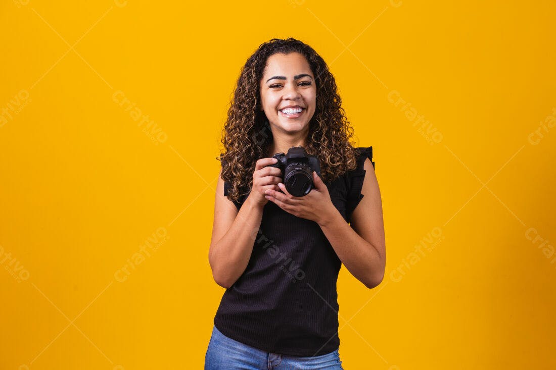 Fotógrafa feliz com câmera DSLR fundo amarelo