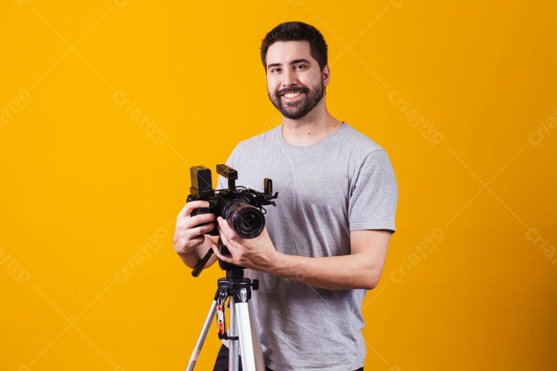 Homem sorrindo com câmera profissional em fundo amarelo