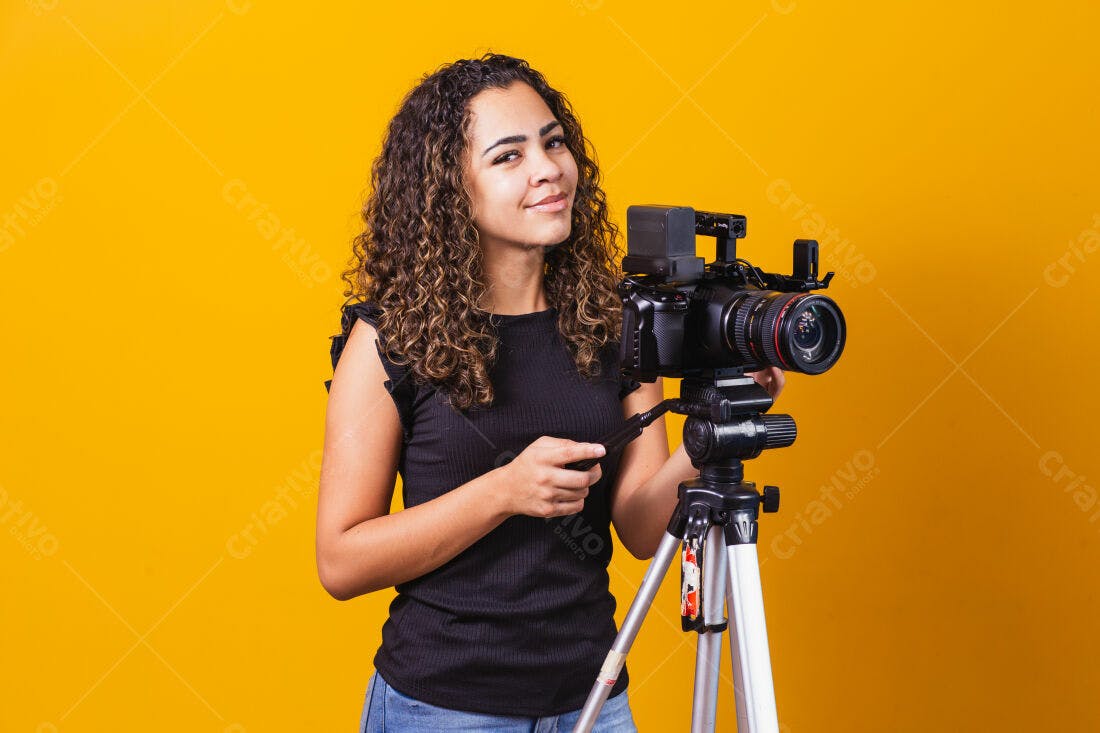 Mulher com câmera profissional fundo amarelo