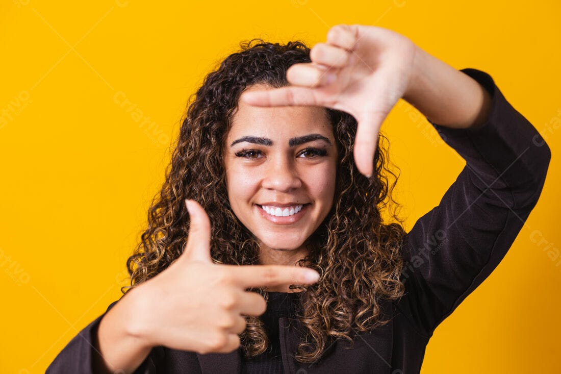 Mulher sorridente com moldura de mãos fundo amarelo