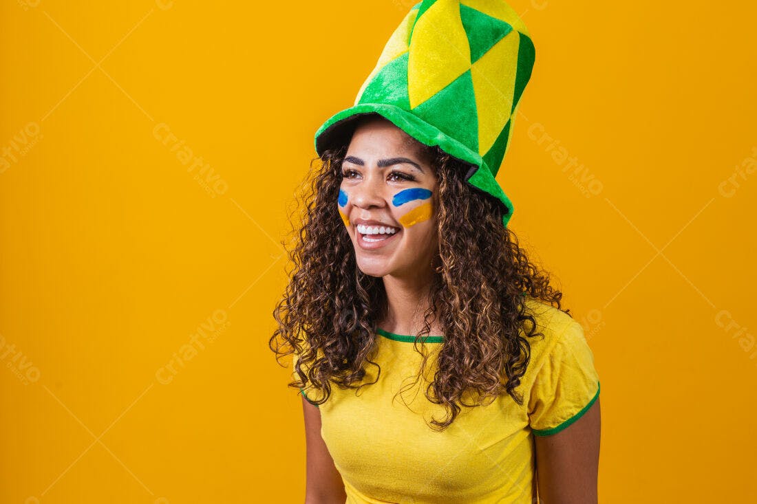 Torcedora brasileira sorridente com chapéu e pintura facial