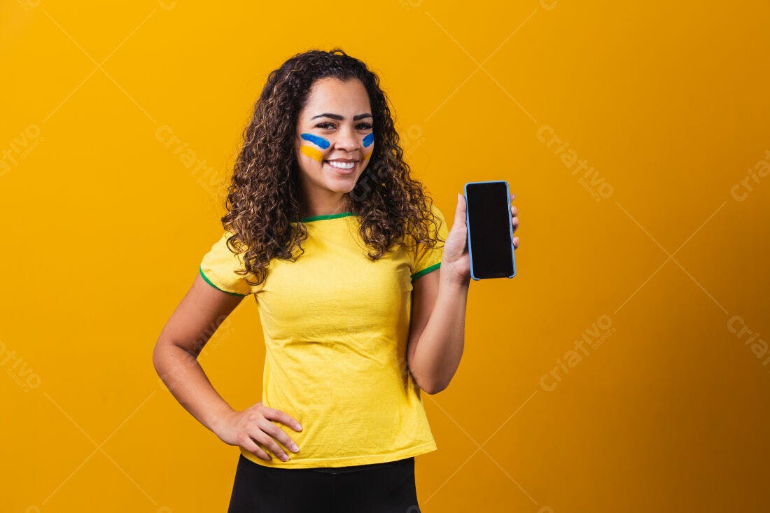 Mulher brasileira mostrando celular fundo amarelo