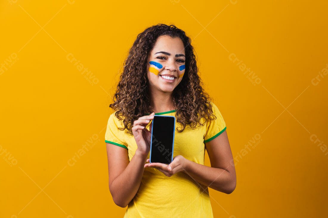 Mulher brasileira mostrando celular fundo amarelo