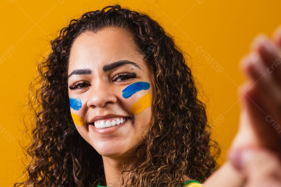 Mulher sorridente com tinta azul e amarela no rosto