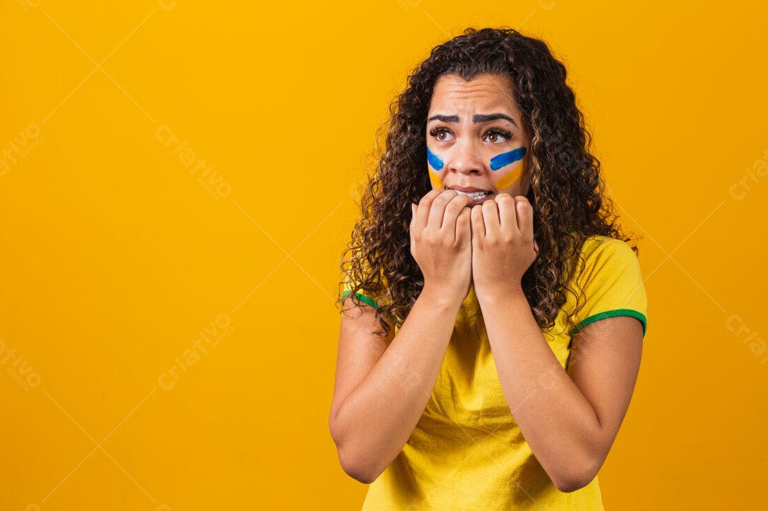 Torcedora apreensiva em fundo amarelo
