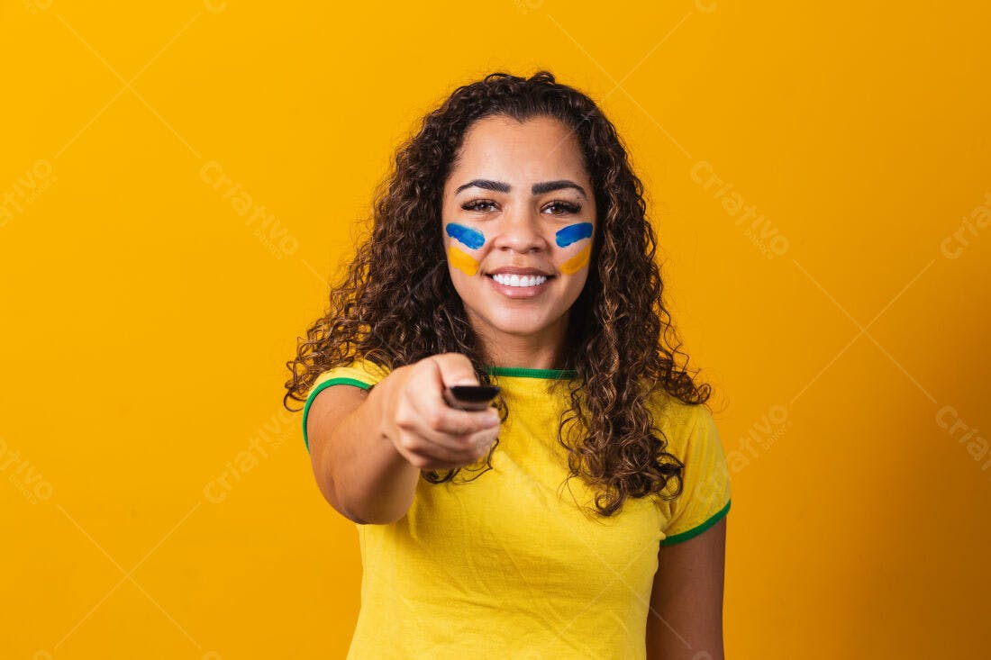 Torcedora brasileira apontando controle remoto