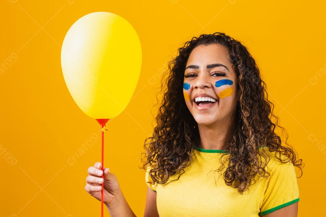 Mulher sorridente com balão amarelo e pintura facial